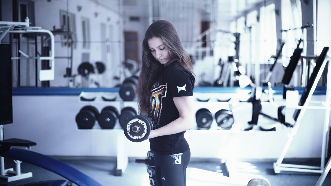 Girl doing bicep curl in the gym